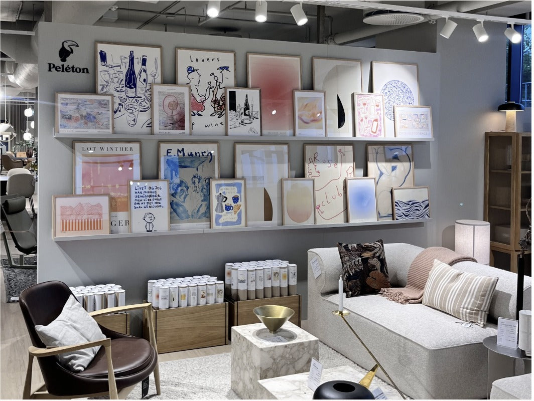 Peleton showroom with poster wall, sofa and armchair
